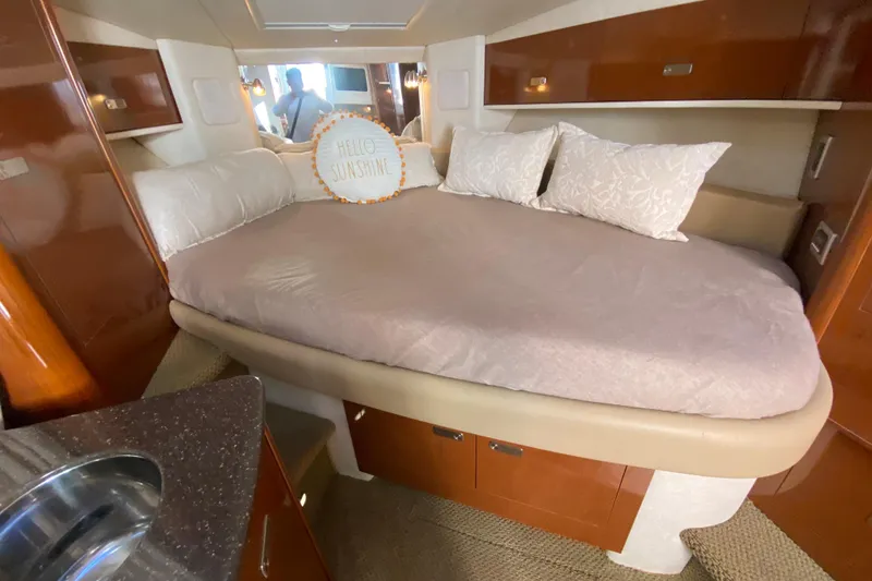 Slide: The Image of Cozy cabin interior of 2012 Sea Ray 330 Sundancer with plush bedding and "Hello Sunshine" pillow. - 30