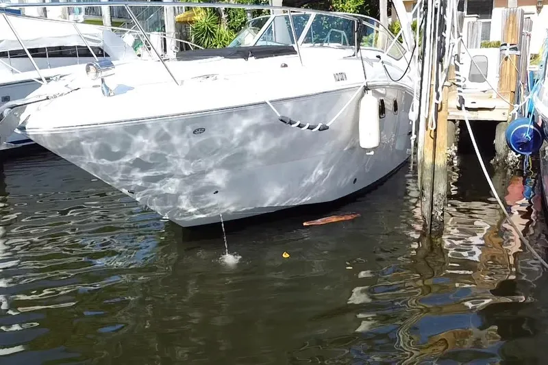 Slide: The Image of 2012 Sea Ray 330 Sundancer docked in a marina, reflecting sunlight on water. - 5