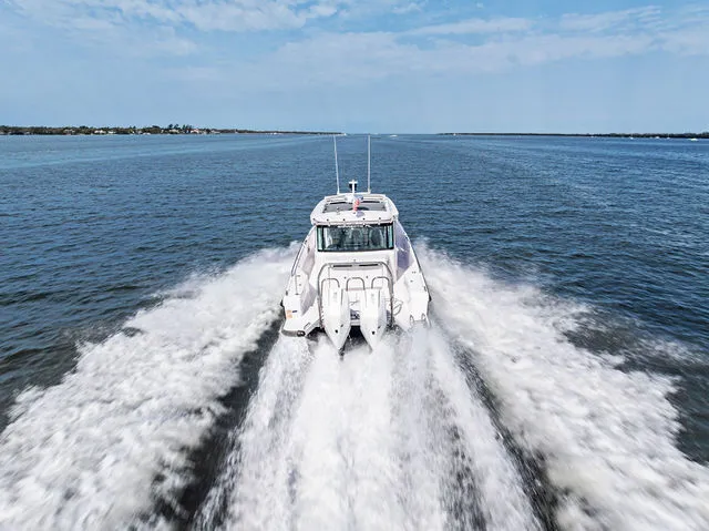 Slide: The Image of 2022 Axopar 37 XC Cross Cabin boat with cushioned seating on open water. - 16
