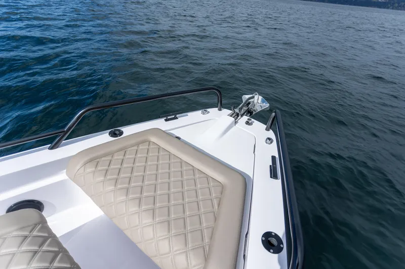 Slide: The Image of 2022 Axopar 37 XC Cross Cabin boat with cushioned seating on open water. - 18