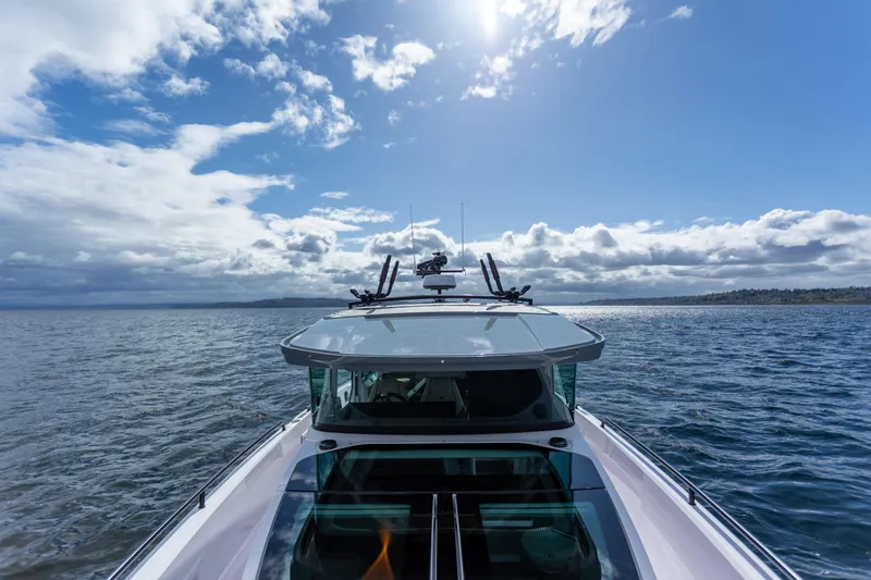 Slide: The Image of 2022 Axopar 37 XC Cross Cabin boat cruising under a bright blue sky. - 19