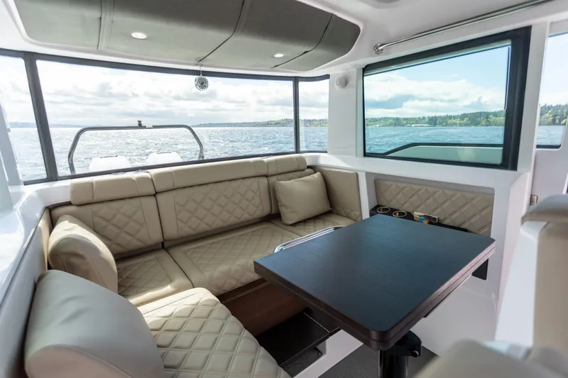 Slide: The Image of Luxurious interior of 2022 Axopar 37 XC Cross Cabin with plush seating and scenic water view. - 27