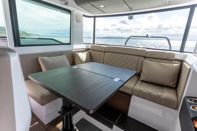 Slide: The Image of Luxurious interior of 2022 Axopar 37 XC Cross Cabin with plush seating and scenic ocean view. - 29