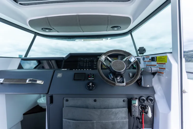 Slide: The Image of 2022 Axopar 37 XC Cross Cabin helm with modern controls and steering wheel. - 33