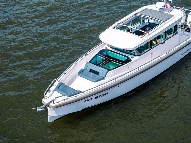 Slide: The Image of 2022 Axopar 37 XC Cross Cabin boat cruising on a scenic waterway. - 7