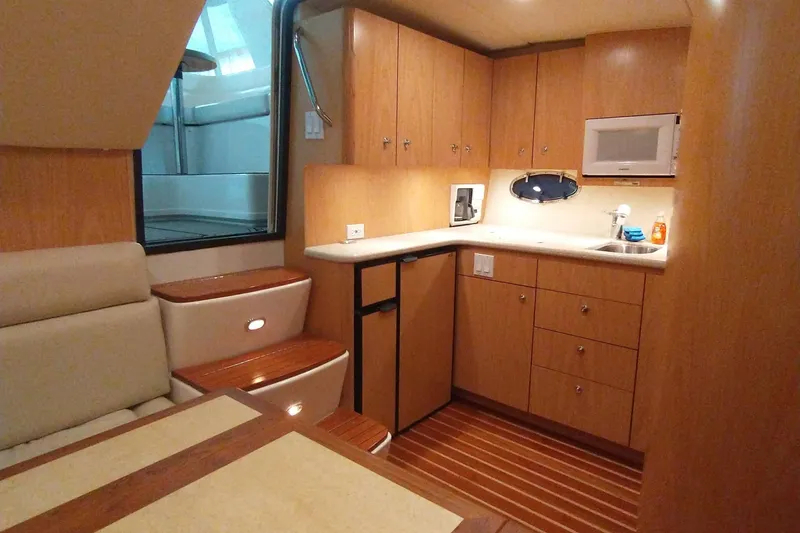 Slide: The Image of Interior of 2001 Tiara Yachts 3800 Open with kitchen and seating area. - 15