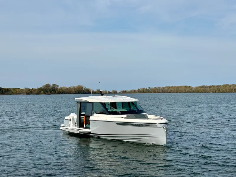 Slide: The Image of 2027 Saxdor 400 GTC on calm water with a wooded shoreline in the background. - 2