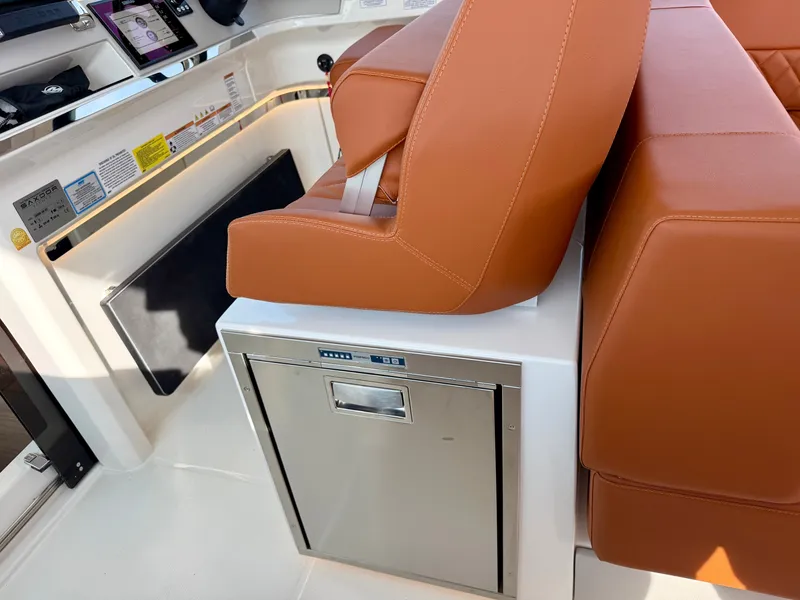 Slide: The Image of Brown leather seats and a stainless steel refrigerator on a boat. - 21