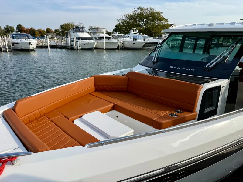 Slide: The Image of The image shows a Saxdor 400 GTC boat with brown upholstery at a marina. - 27