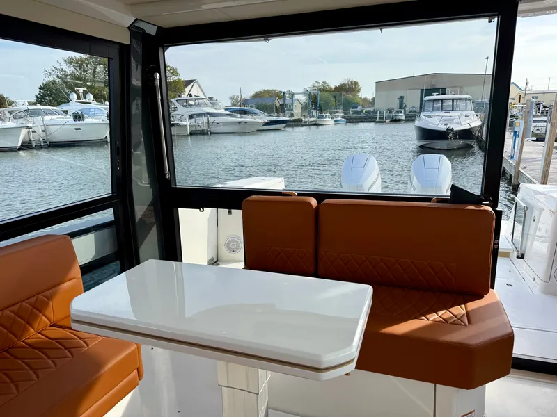 Slide: The Image of Interior of the Saxdor 400 GTC with orange seating and a white table, docked at a marina. - 13