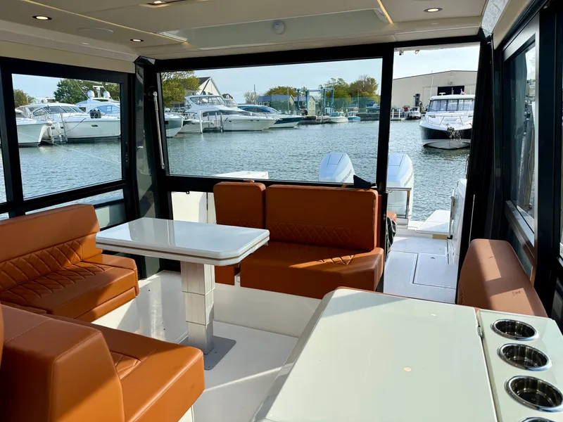 Slide: The Image of Interior of the Saxdor 400 GTC with brown seating and a table, overlooking the marina. - 11