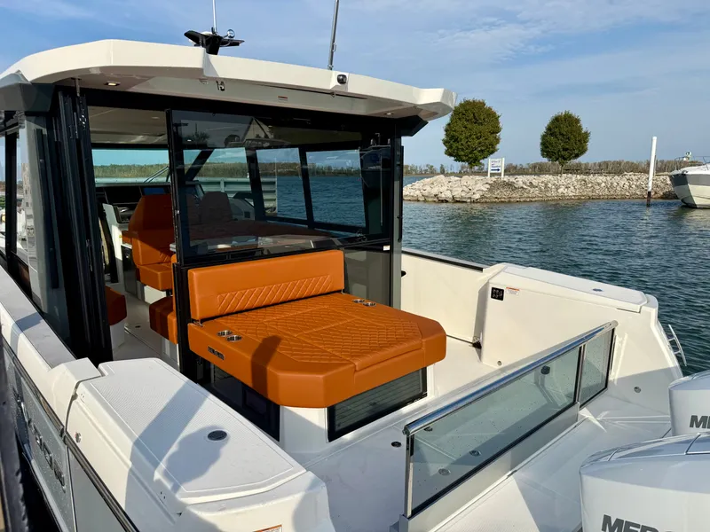 Slide: The Image of 2027 Saxdor 400 GTC with orange seating, on calm water near a rocky shoreline. - 6