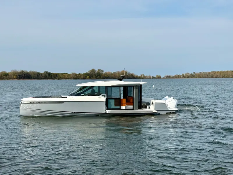 Slide: The Image of A 2027 Saxdor 400 GTC cruising on calm waters with a wooded shoreline in the background. - 4