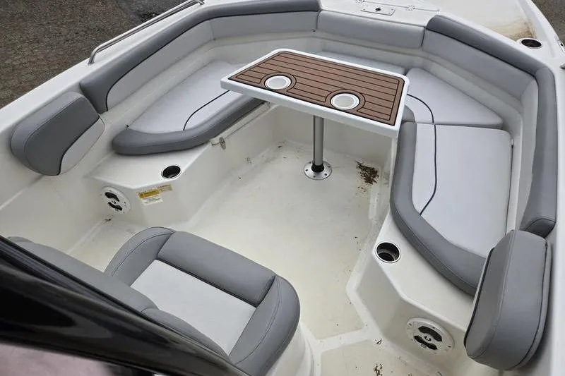 Slide: The Image of 2021 NauticStar 231 Hybrid boat interior with cushioned seating and a central table. - 10