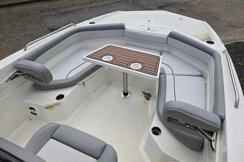Slide: The Image of 2021 NauticStar 231 Hybrid boat interior with cushioned seating and a central table. - 11