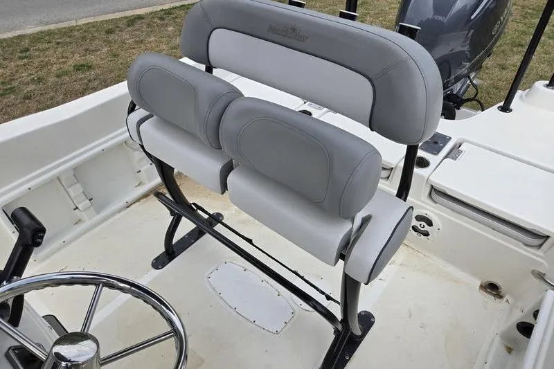 Slide: The Image of 2021 NauticStar 231 Hybrid boat interior with gray seating and steering wheel. - 13