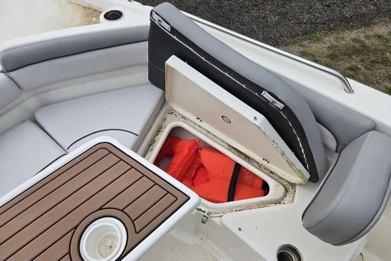 Slide: The Image of 2021 NauticStar 231 Hybrid boat with open storage compartment and life jackets. - 16