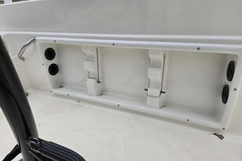 Slide: The Image of 2021 NauticStar 231 Hybrid boat interior storage compartment with cup holders and grab handle. - 7