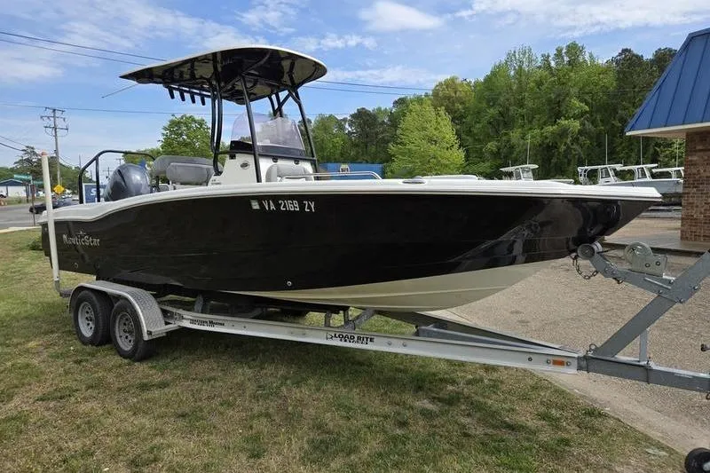 Slide: The Image of 2021 NauticStar 231 Hybrid boat on trailer, parked outdoors. - 8