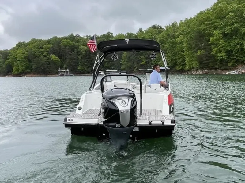 Slide: The Image of A 2025 Starcraft SVX OB 230 DC OB on a calm lake with wooded shores. - 7