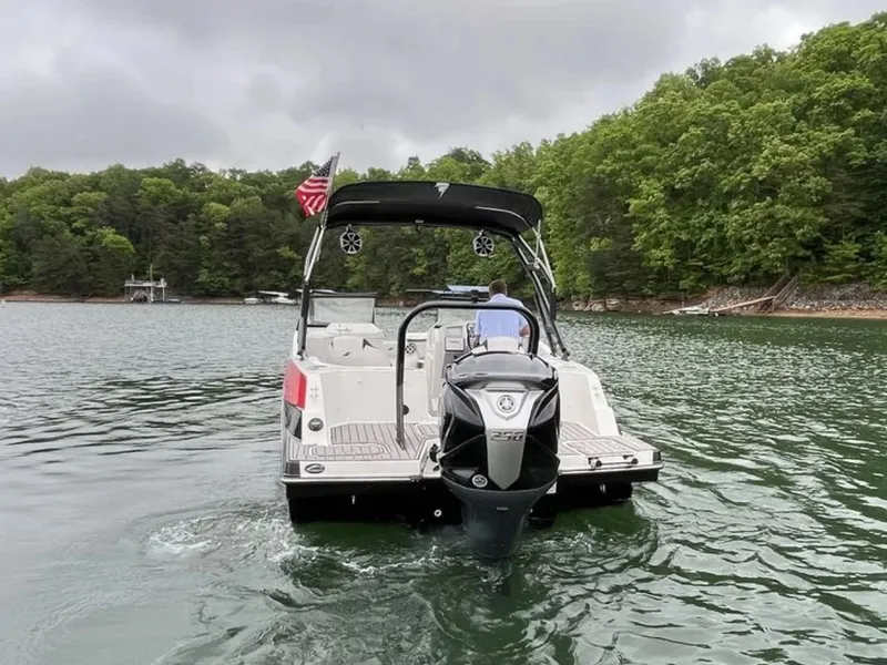Slide: The Image of A 2025 Starcraft SVX OB 230 DC OB on a calm lake with wooded shores. - 15