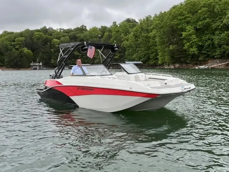 Slide: The Image of A modern Starcraft boat on a calm lake, surrounded by lush green trees. - 1