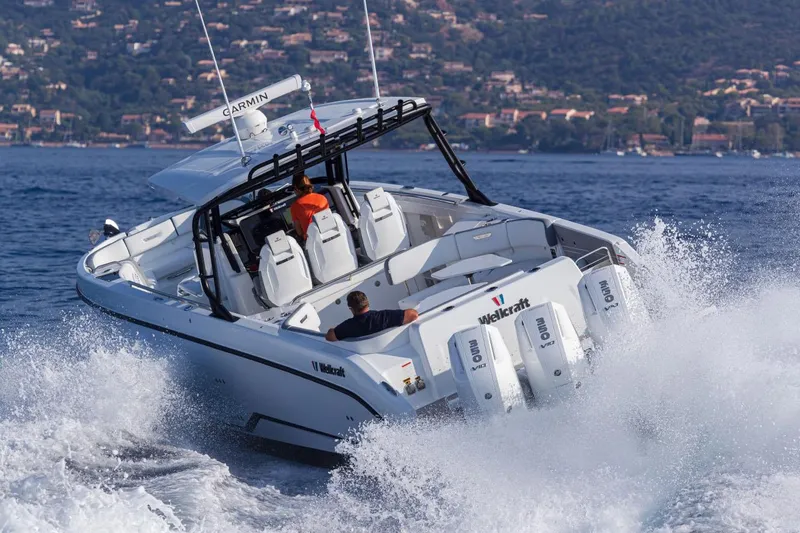 Slide: The Image of Manufacturer Provided Image: 2026 Wellcraft 38 T-Top boat navigating waves, showcasing powerful engines and sleek design. - 10