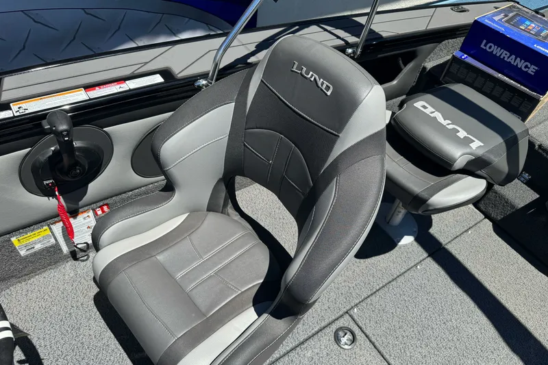 Slide: The Image of 2026 Lund 1875 Crossover XS boat interior with branded seats and Lowrance equipment. - 18