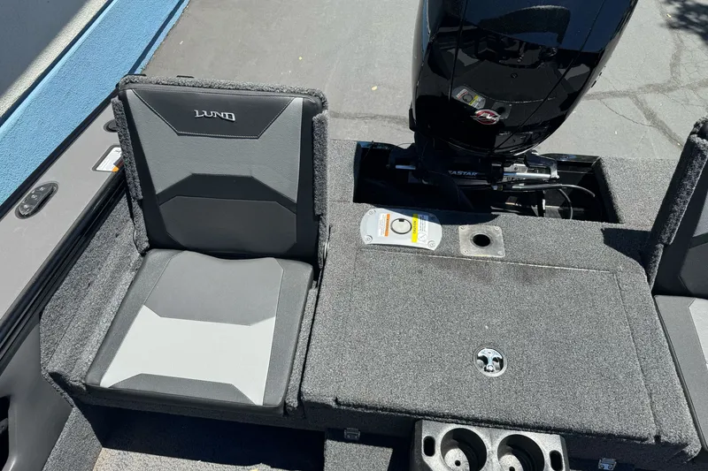 Slide: The Image of 2026 Lund 1875 Crossover XS boat interior with seating and motor detail. - 14