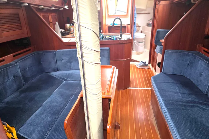 Slide: The Image of Interior of a 1990 Tartan 372 sailboat with blue seating and wooden finishes. - 16