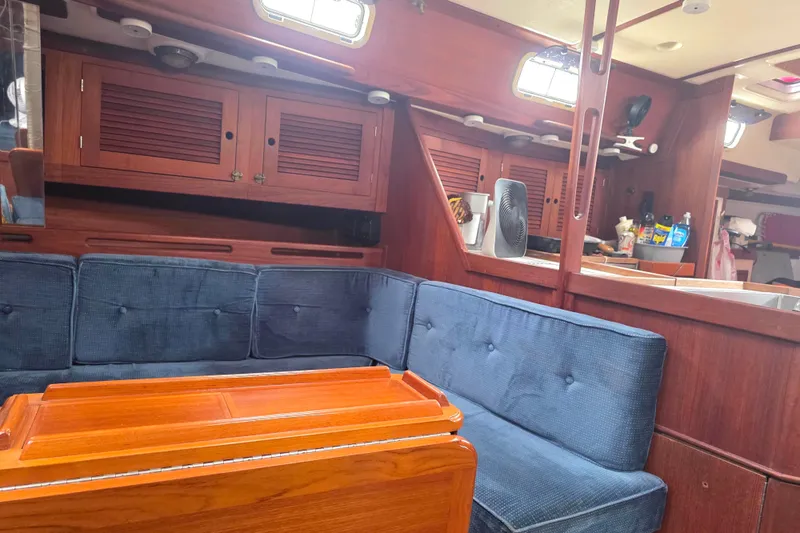 Slide: The Image of Interior of 1990 Tartan 372 sailboat with blue seating and wooden cabinetry. - 18