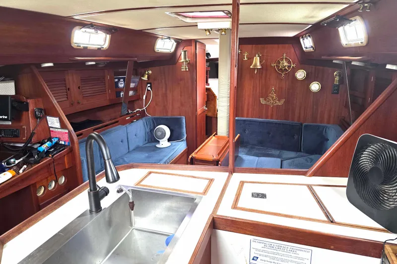 Slide: The Image of Interior of a 1990 Tartan 372 sailboat with wood finish and blue seating. - 20