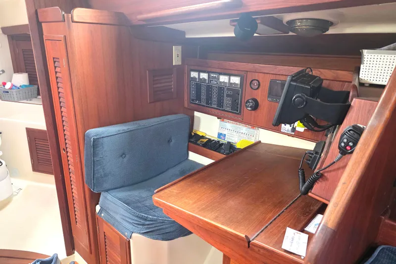Slide: The Image of Navigation station in a 1990 Tartan 372 sailboat with wooden interior and control panels. - 22
