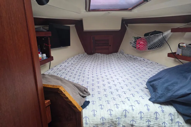Slide: The Image of Cozy cabin interior of 1990 Tartan 372 sailboat with anchor-patterned bedding. - 23