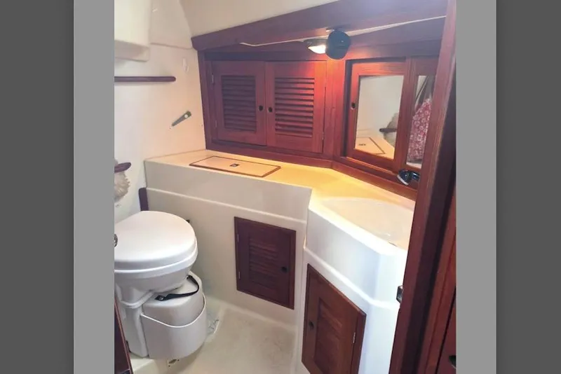 Slide: The Image of 1990 Tartan 372 yacht bathroom with wooden cabinets and compact toilet. - 25