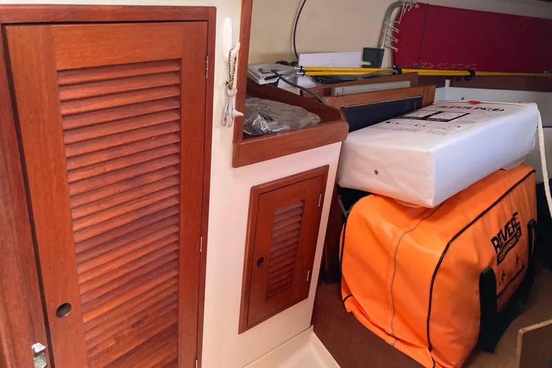 Slide: The Image of Interior of 1990 Tartan 372 sailboat with wooden cabinets and safety equipment. - 26