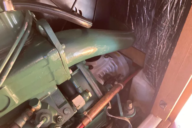 Slide: The Image of Engine compartment of a 1990 Tartan 372 sailboat, showcasing mechanical components and piping. - 32