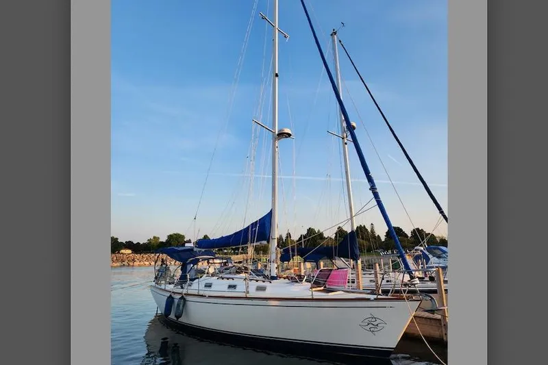Slide: The Image of Sailboat docked at marina, Tartan 372 model, 1990, with blue sails and clear sky. - 33