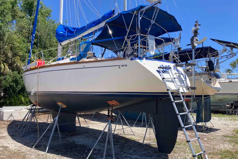 Slide: The Image of 1990 Tartan 372 sailboat on stands, blue canopy, ladder access, outdoor setting. - 4