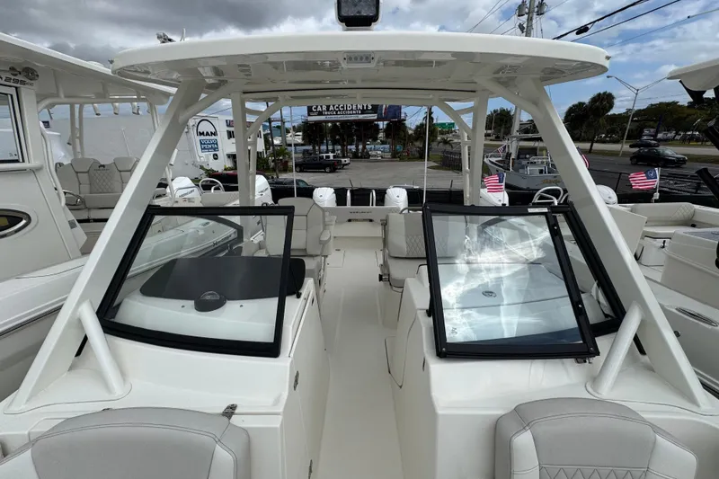 Slide: The Image of 2024 World Cat 260 DC-X boat interior with dual consoles and seating under cloudy sky. - 21