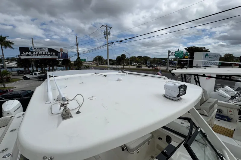 Slide: The Image of 2024 World Cat 260 DC-X boat rooftop view with urban background and cloudy sky. - 23