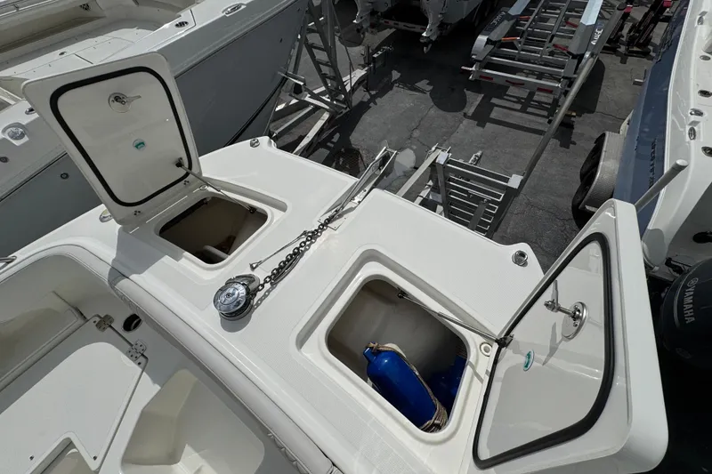 Slide: The Image of 2024 World Cat 260 DC-X boat deck with open storage compartments and anchor chain. - 25