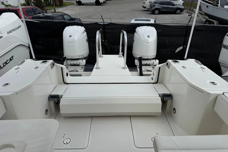 Slide: The Image of 2024 World Cat 260 DC-X boat with dual outboard engines, docked in a marina. - 49