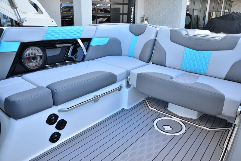 Slide: The Image of 2023 MasterCraft XT22 T boat interior with gray and blue seating, modern design. - 12