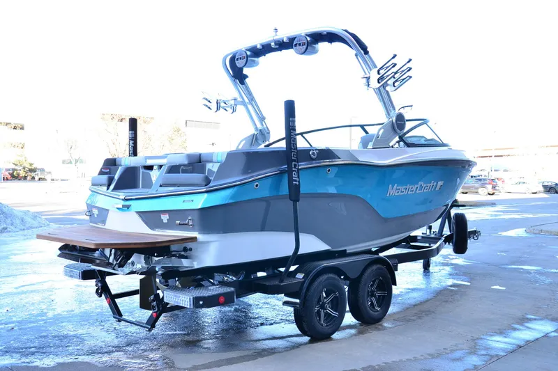 Slide: The Image of 2023 MasterCraft XT22 T boat on trailer, showcasing sleek design and vibrant blue color. - 5