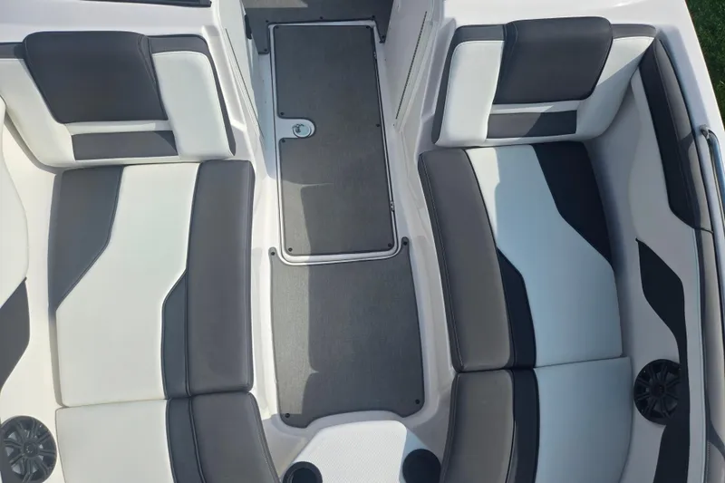 Slide: The Image of 2022 Yamaha Boats AR210 interior seating with gray and white upholstery. - 19