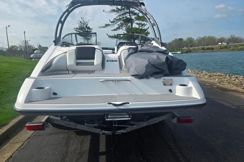 Slide: The Image of 2022 Yamaha AR210 boat on trailer by a lakeside, ready for launch. - 2