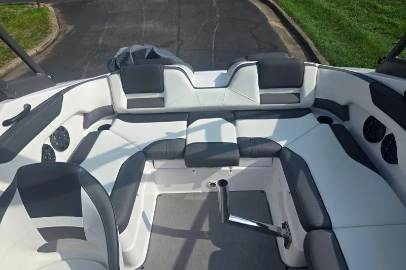 Slide: The Image of 2022 Yamaha Boats AR210 interior with sleek white and gray seating arrangement. - 22