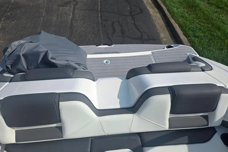 Slide: The Image of 2022 Yamaha Boats AR210 rear seating area with sleek design and covered engine compartment. - 23