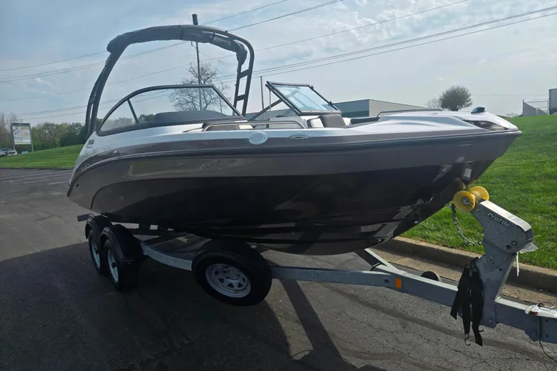 Slide: The Image of 2022 Yamaha AR210 boat on trailer, parked outdoors on a sunny day. - 5